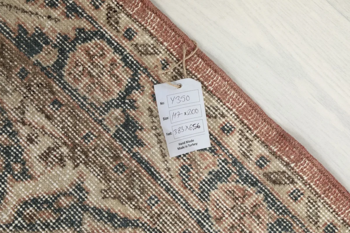 Close-up of the label attached to the back of the rug, showing its dimensions and origin.