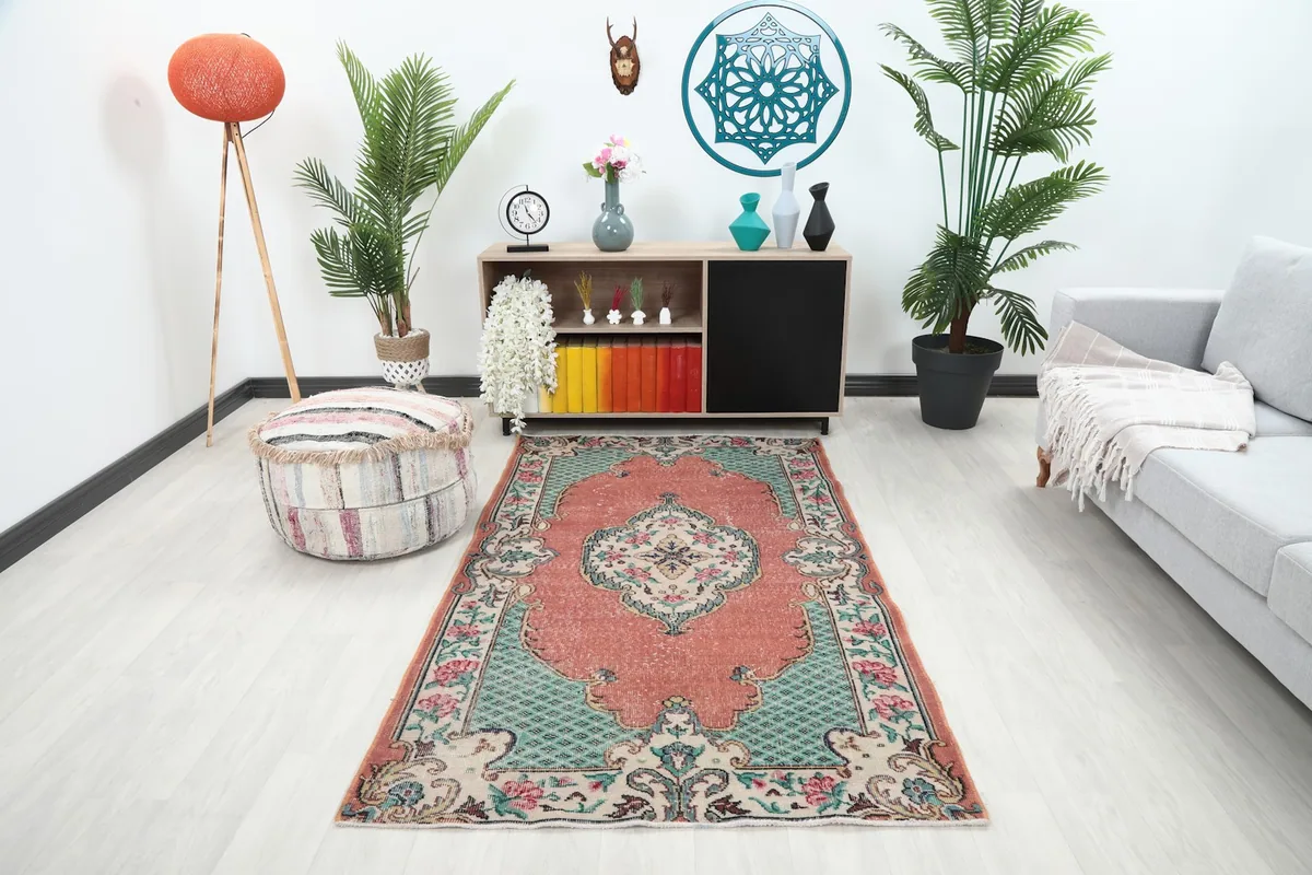 Vintage rose and green floral medallion area rug displayed in a modern living room setting