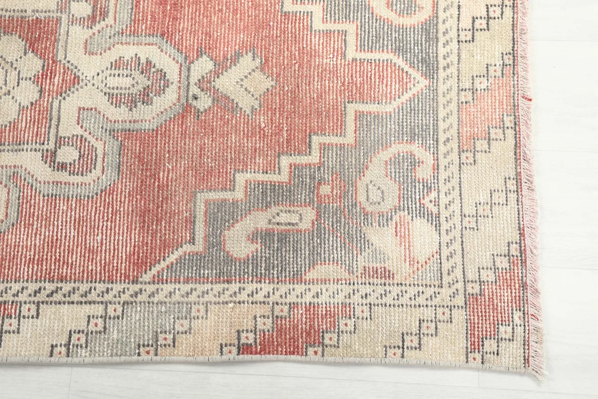 Detailed corner view of the rug, highlighting the geometric border and rust field
