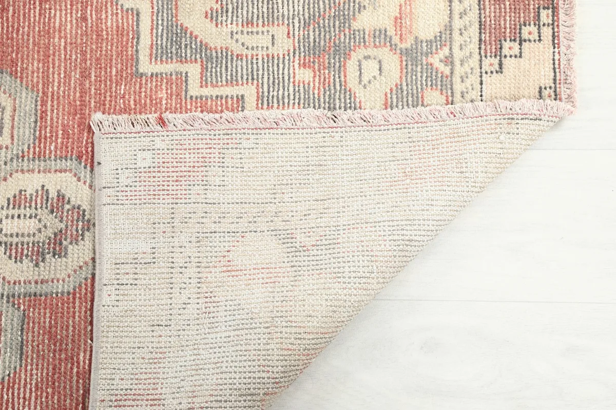 Close-up of the rug's back, showing the tight knotting of the wool pile on cotton