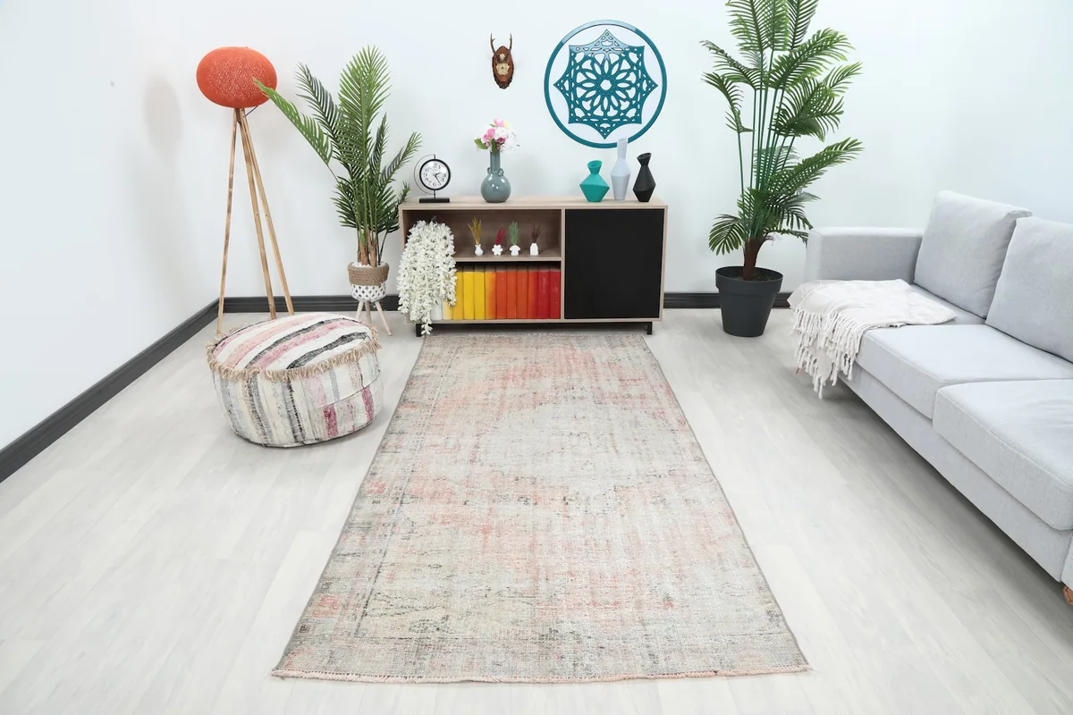 Vintage Anatolian rug displayed in a living room setting, showing its size relative to furniture.