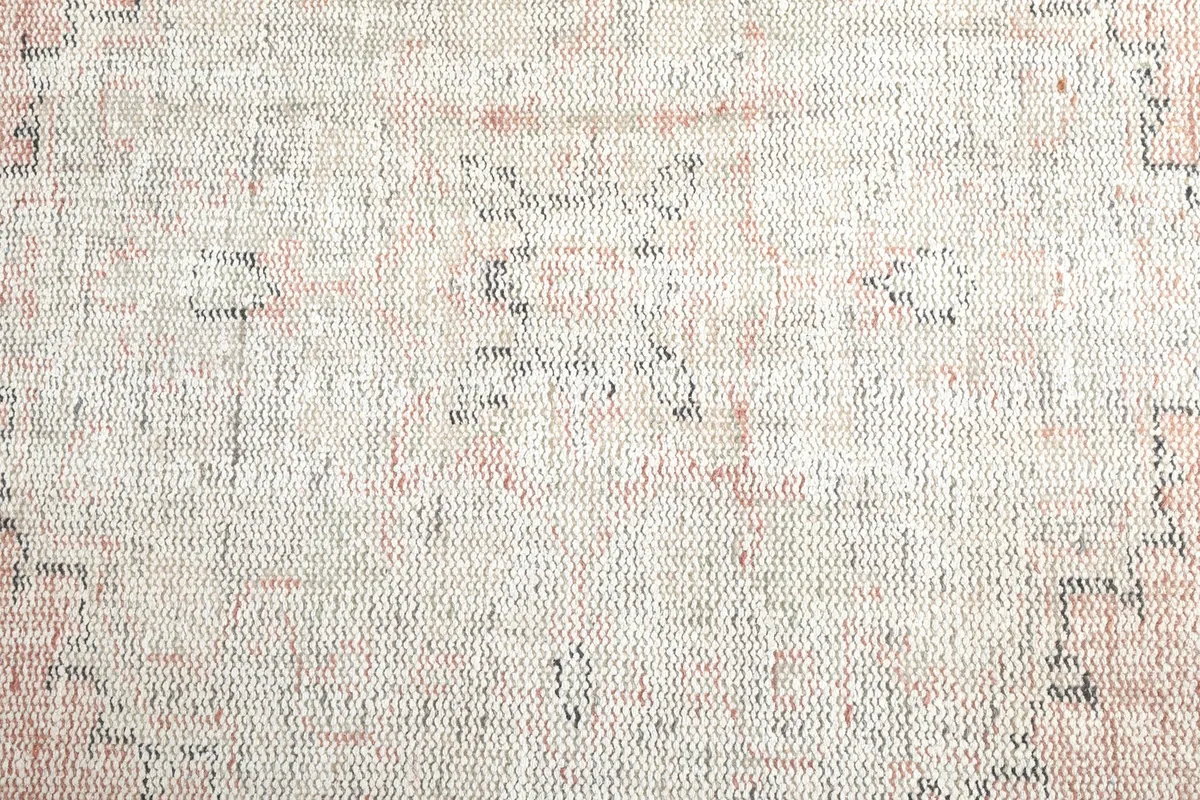 Close-up of the low pile and intricate, faded geometric motifs in the rug's center.