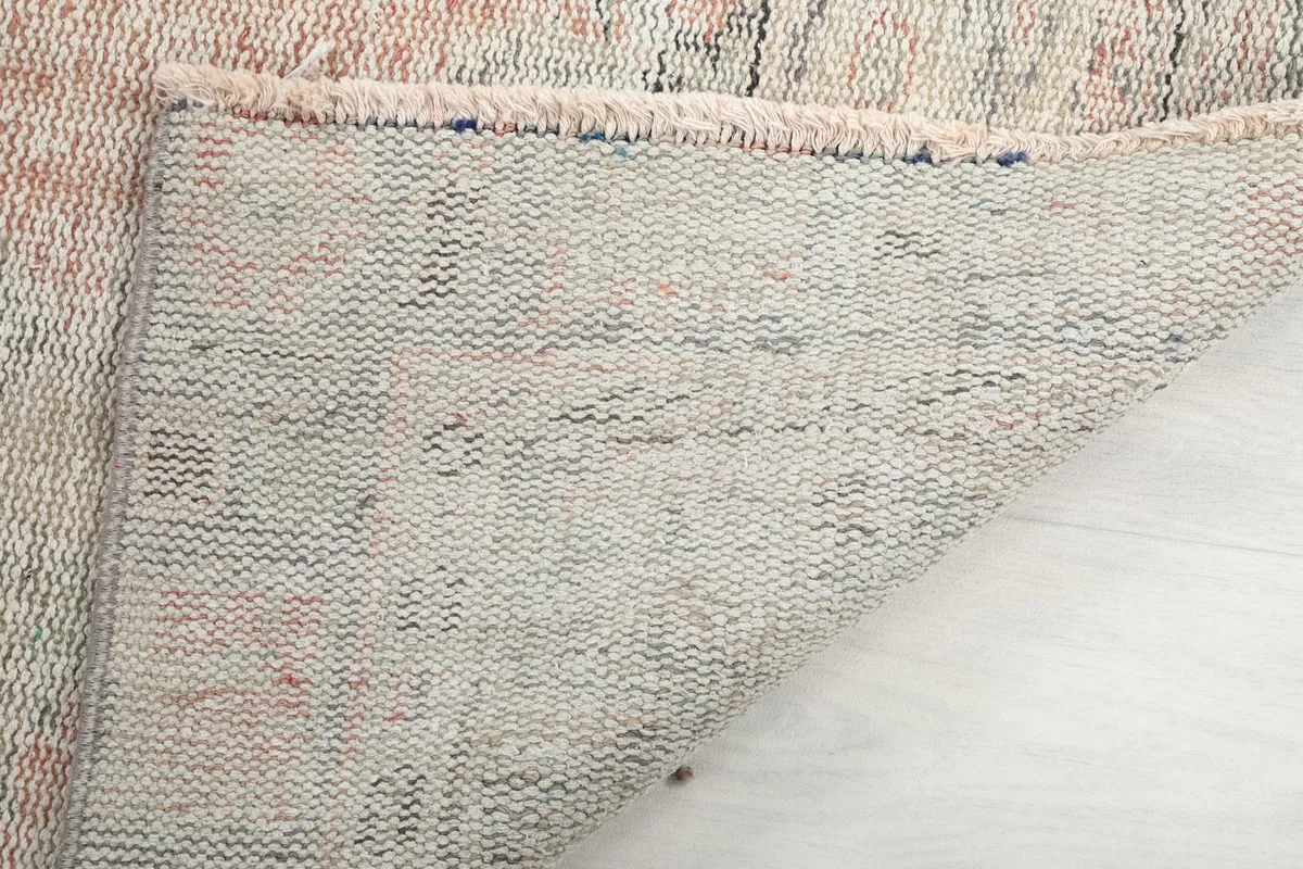 Close-up of the rug's underside, showing the tightly woven cotton foundation and knotting.