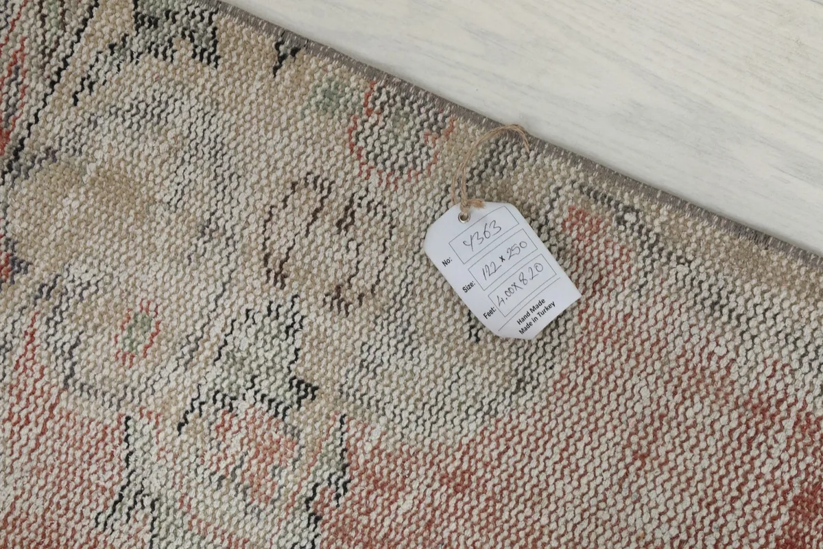 Detail of the rug's label, confirming size and origin, placed on the hand-knotted wool surface.