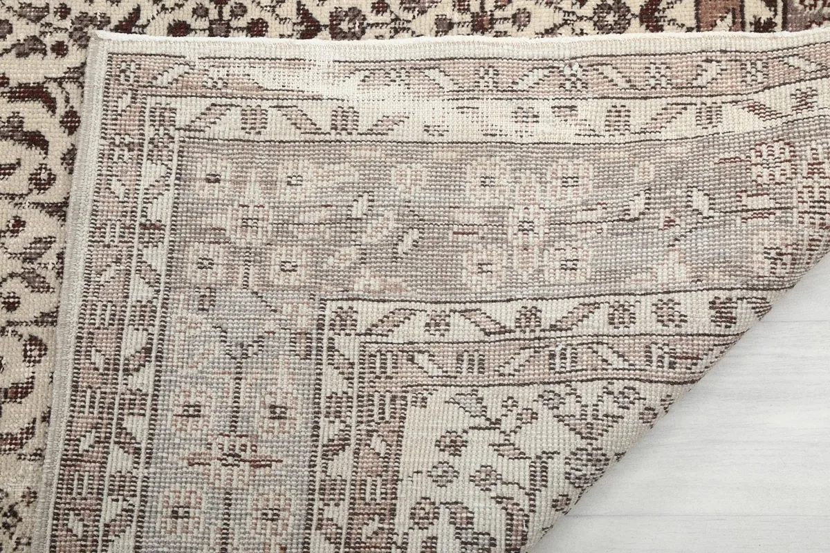Close-up of the back of the rug, showing the knotting structure and the cotton foundation beneath the wool pile.