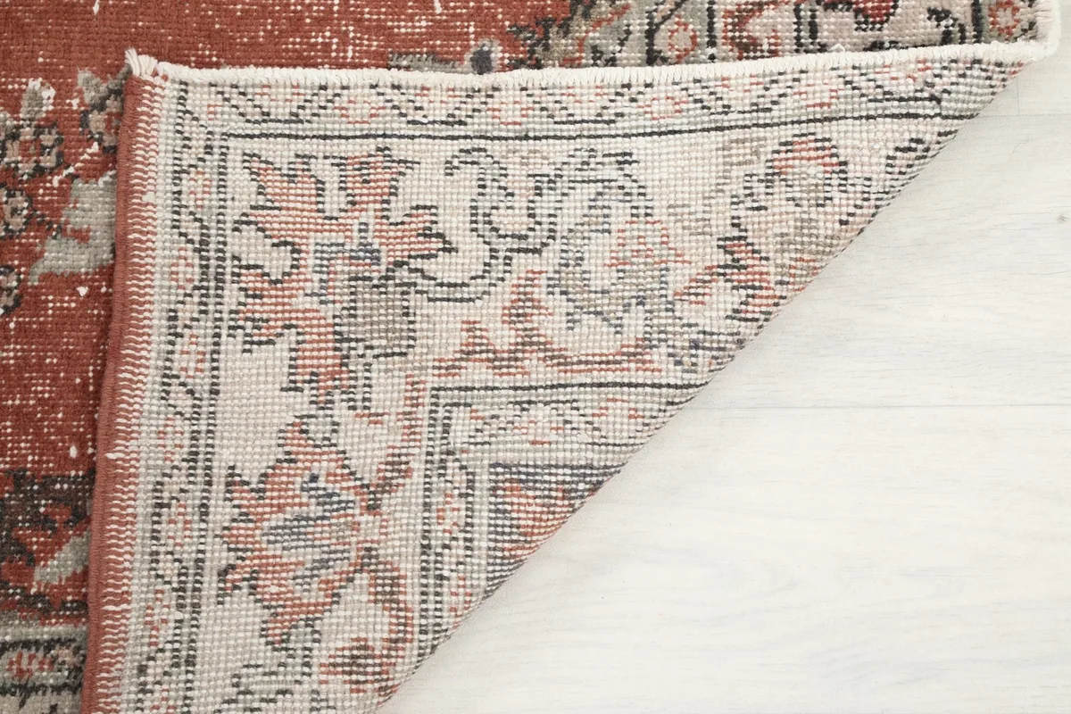 View of the back of the rug, revealing the hand-knotted cotton foundation