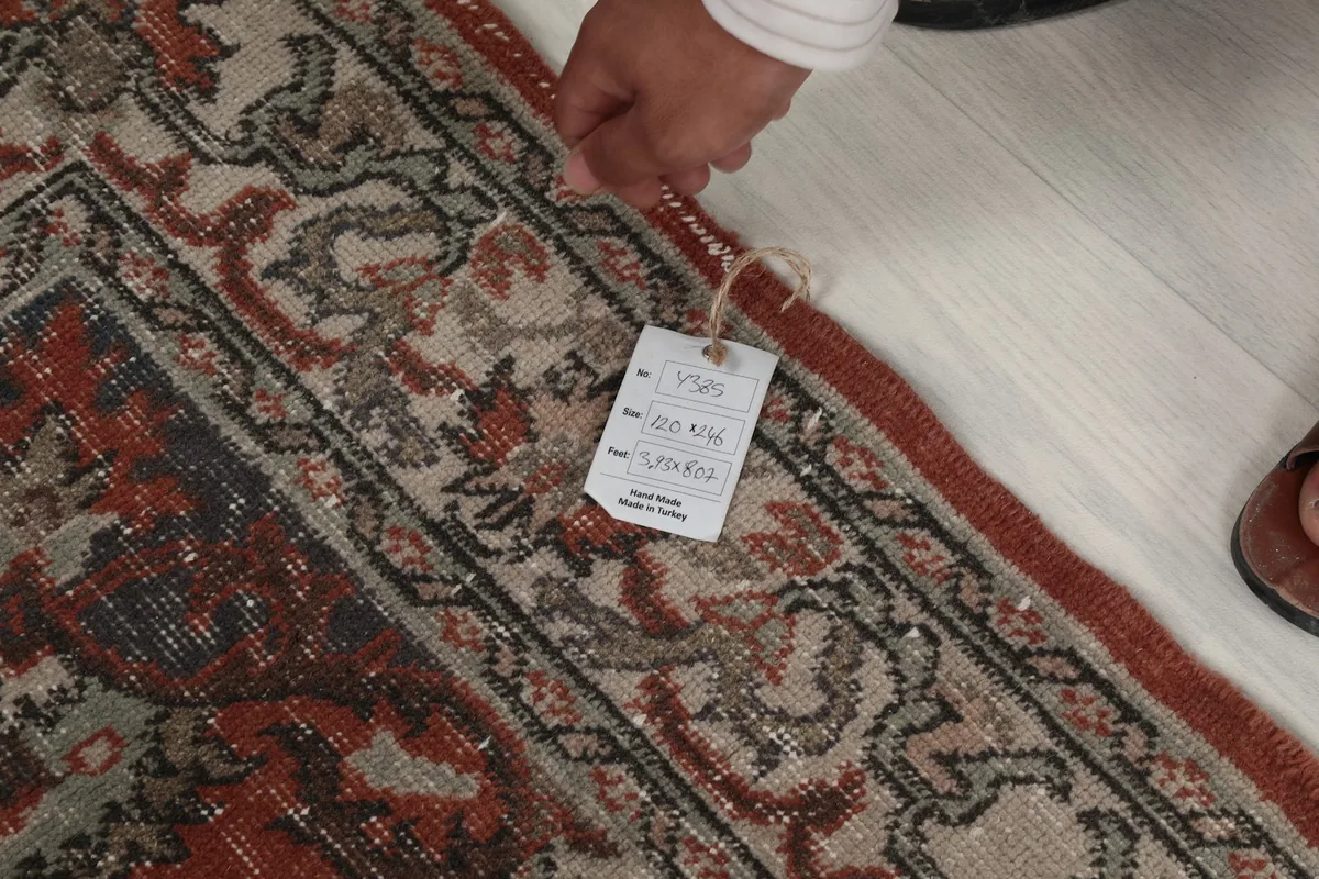 Detail of the rug with a tag, showing the wool pile and construction