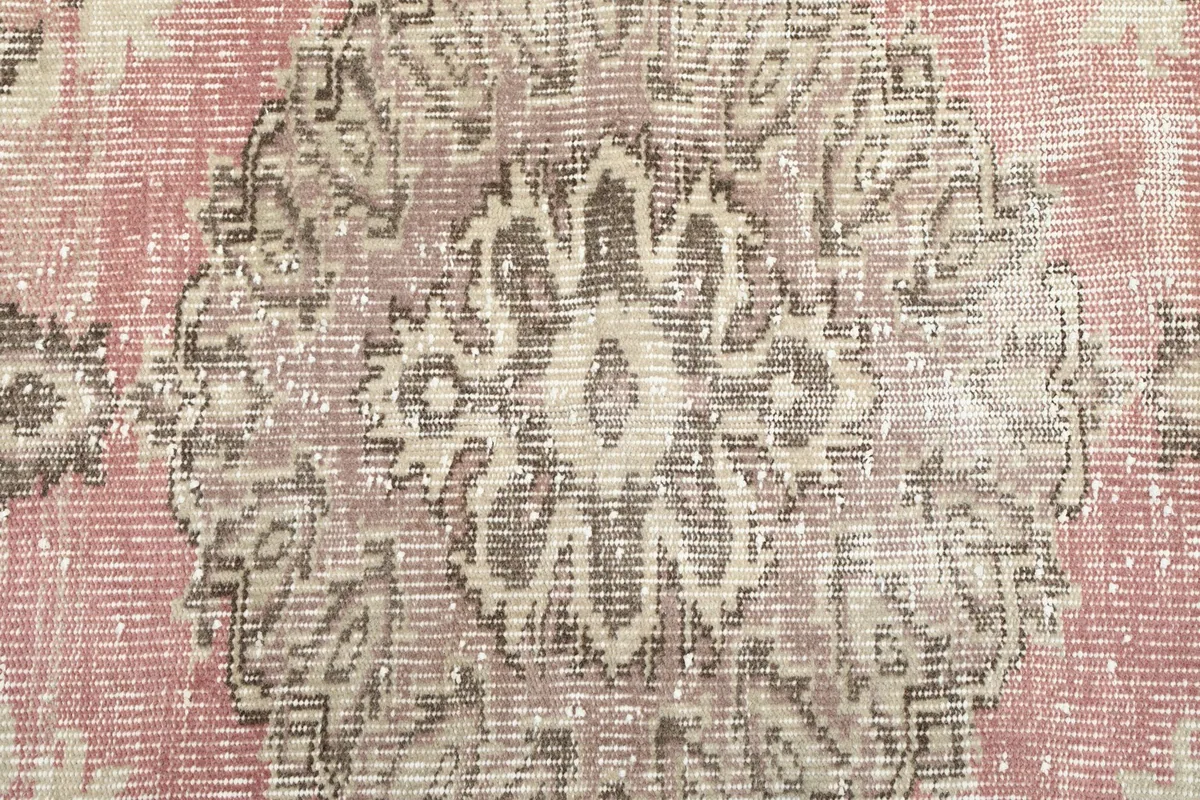 Intricate detail of the central medallion's pattern, showing the wool pile and color variations.