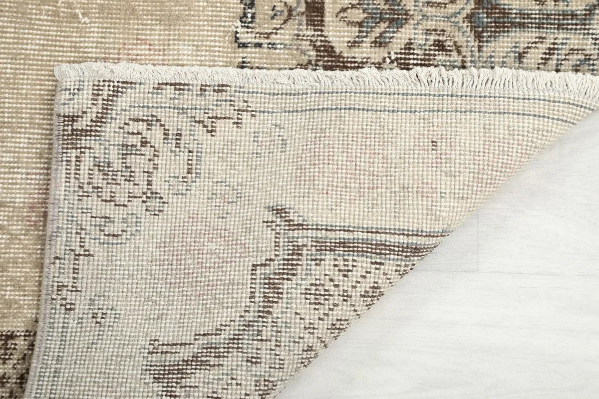 Close-up of the rug's back, showing the hand-knotted construction and fringe