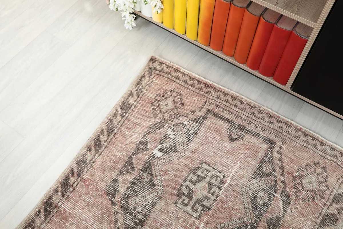 View of the runner's upper section, showing part of the pattern and background elements like a bookshelf.