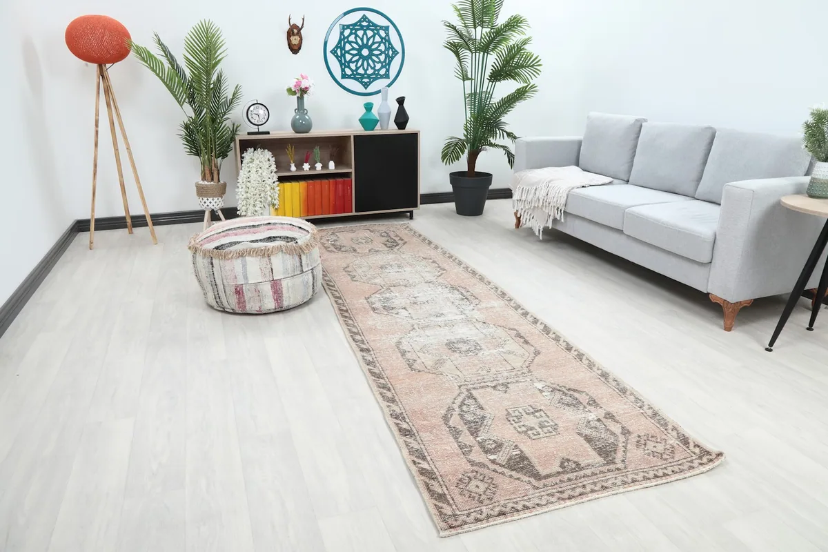Angled view of the rose and charcoal runner rug in a room setting, highlighting its colors and pattern.