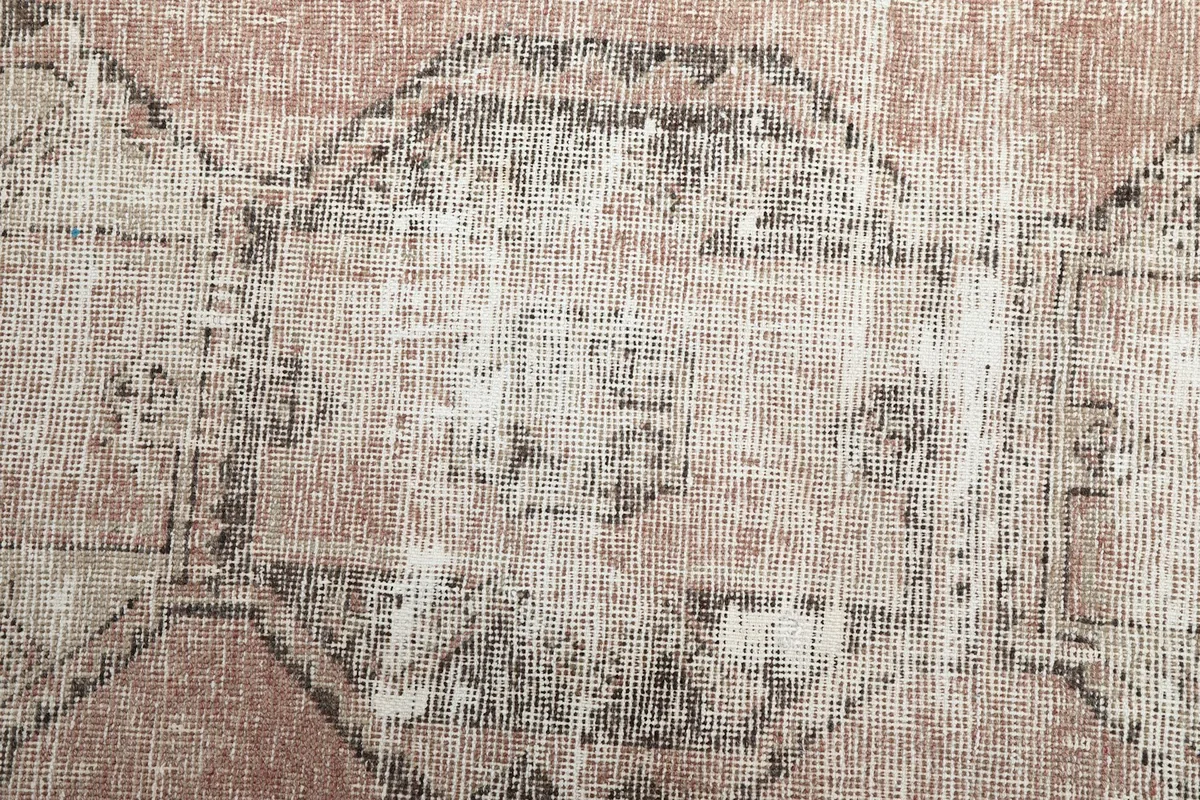 Close-up of the wool pile and distressed texture, revealing the hand-knotted construction and color variations.