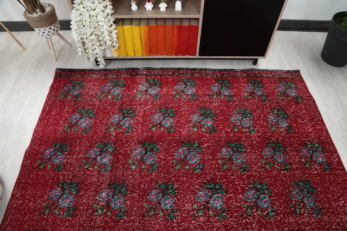 Full view of the red floral rug in a room from a slightly elevated perspective.