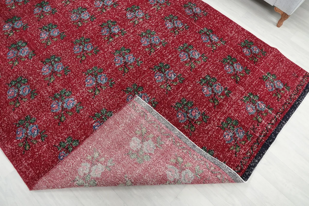 Corner of the rug folded back to reveal the cotton foundation and the reverse side of the pattern.