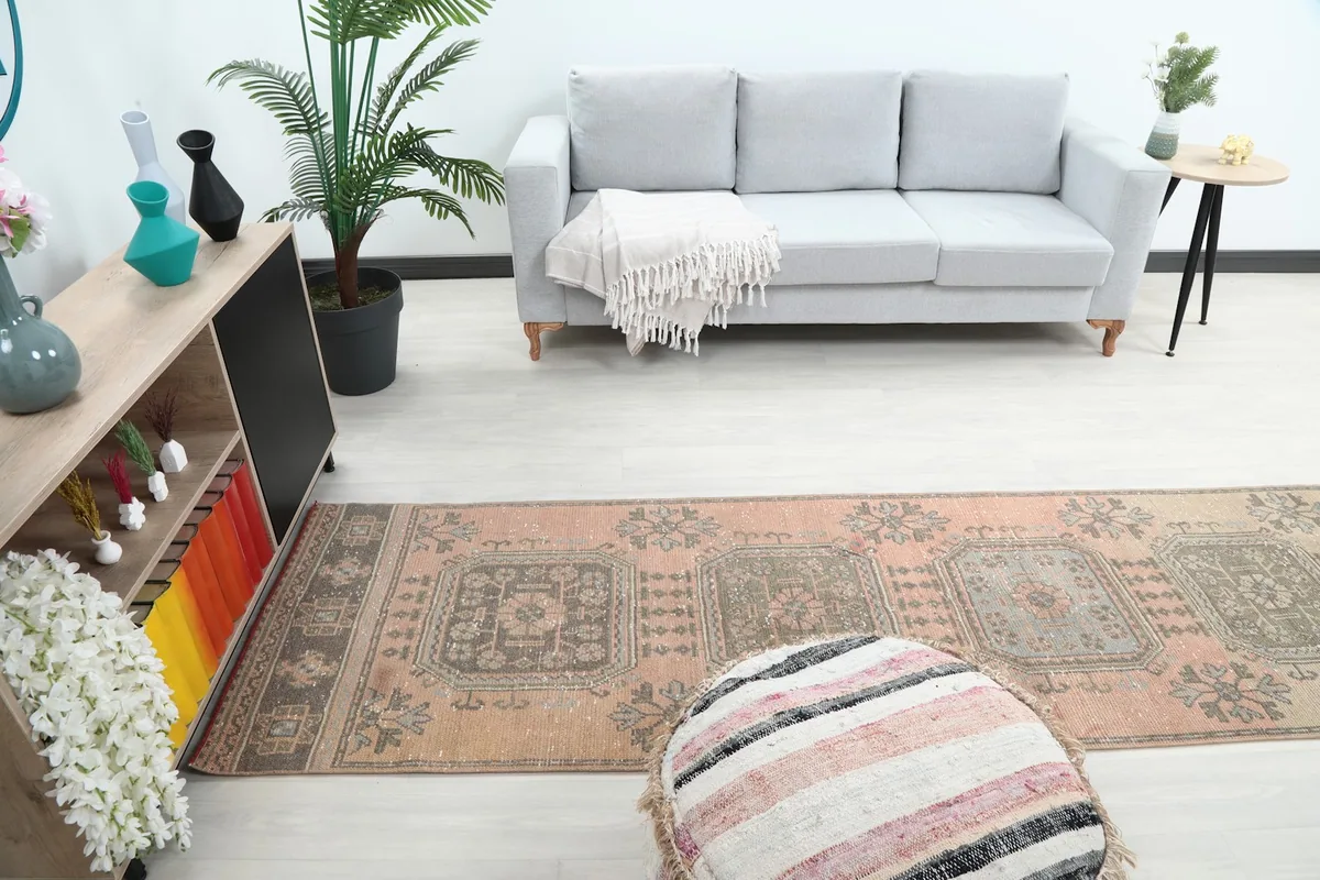 Long shot of the runner rug in a room, showing its scale relative to a sofa and decor.