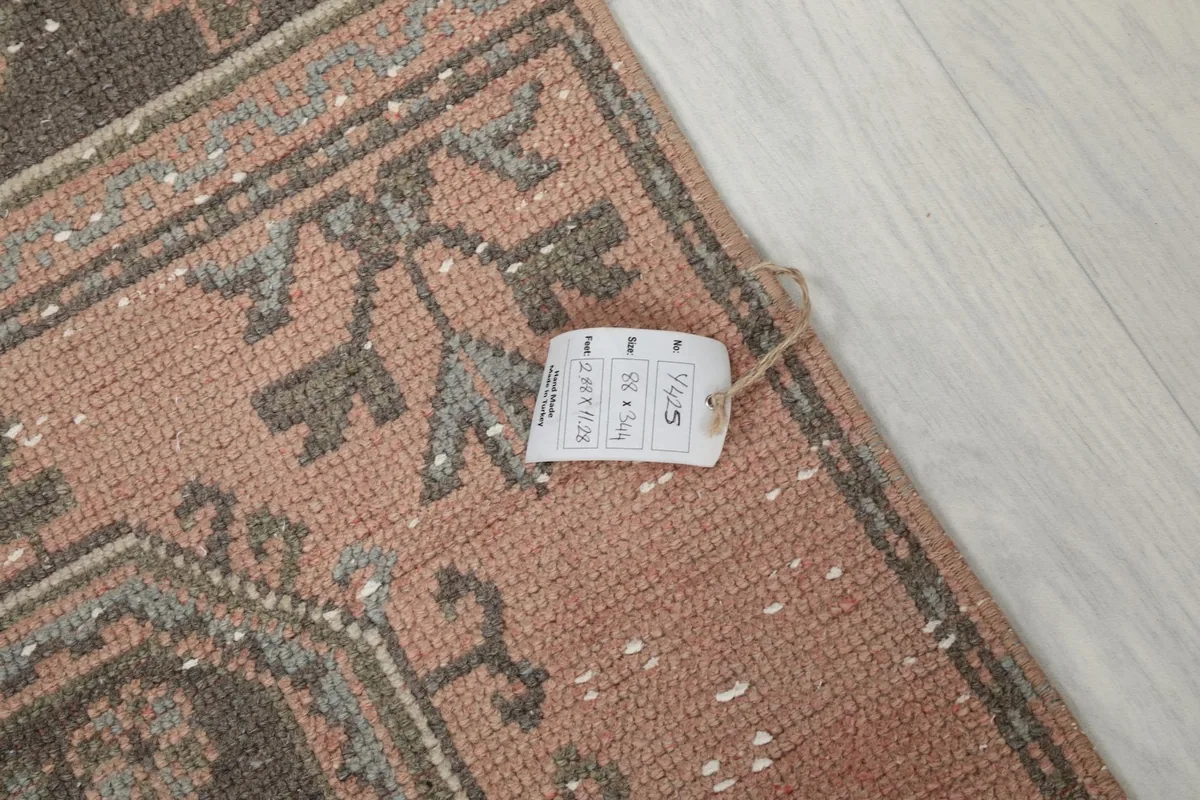Rug tag displaying size and material information, attached to the corner of the runner.