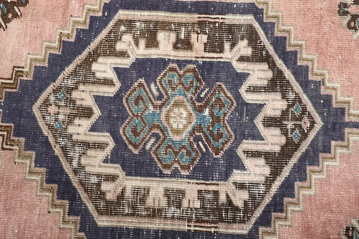 Close-up of the intricate geometric pattern within the navy medallion