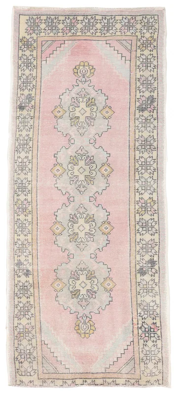Full overhead view of the vintage rose Anatolian runner with geometric medallions