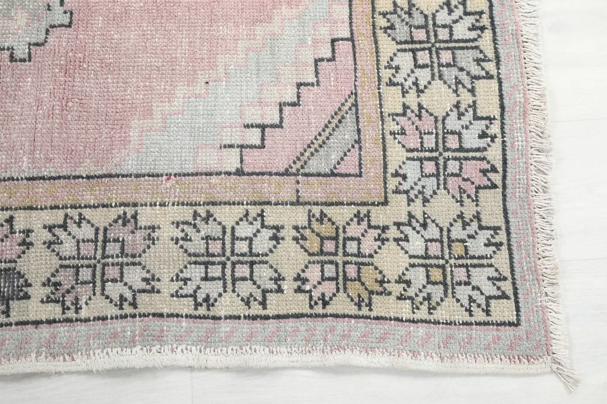 Detail of the geometric border pattern and a corner of the rose runner