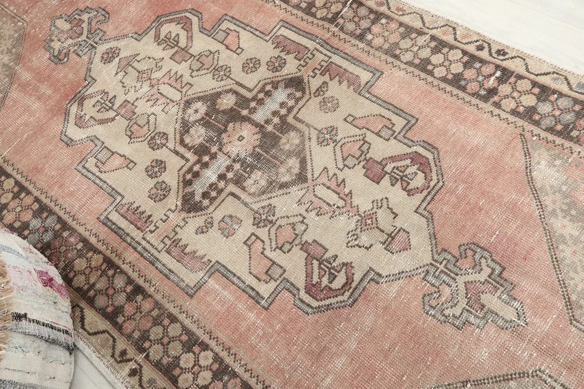 Angled view focusing on the central geometric medallion with ivory and brown details