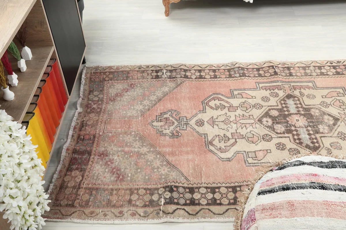 View of the rose runner rug in a room, positioned between a cabinet and a sofa