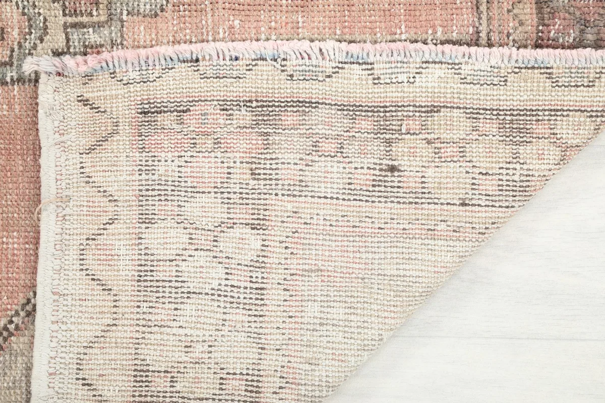 Corner of the rug folded to show the hand-knotted wool pile on cotton foundation