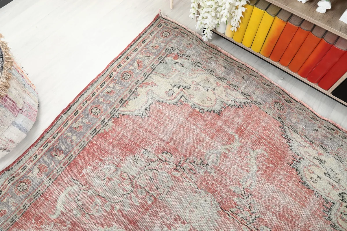 Overhead angle view capturing the full design and colors of the rose and gray rug.