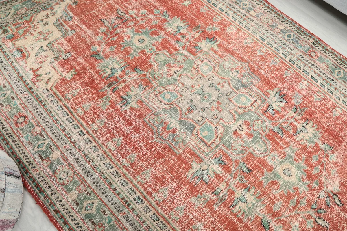 Diagonal view across the rug, focusing on the central medallion and faded rust field