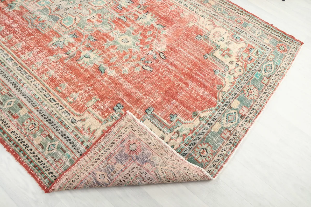Corner of the rug folded back to reveal the back of the hand-knotted wool pile and cotton foundation