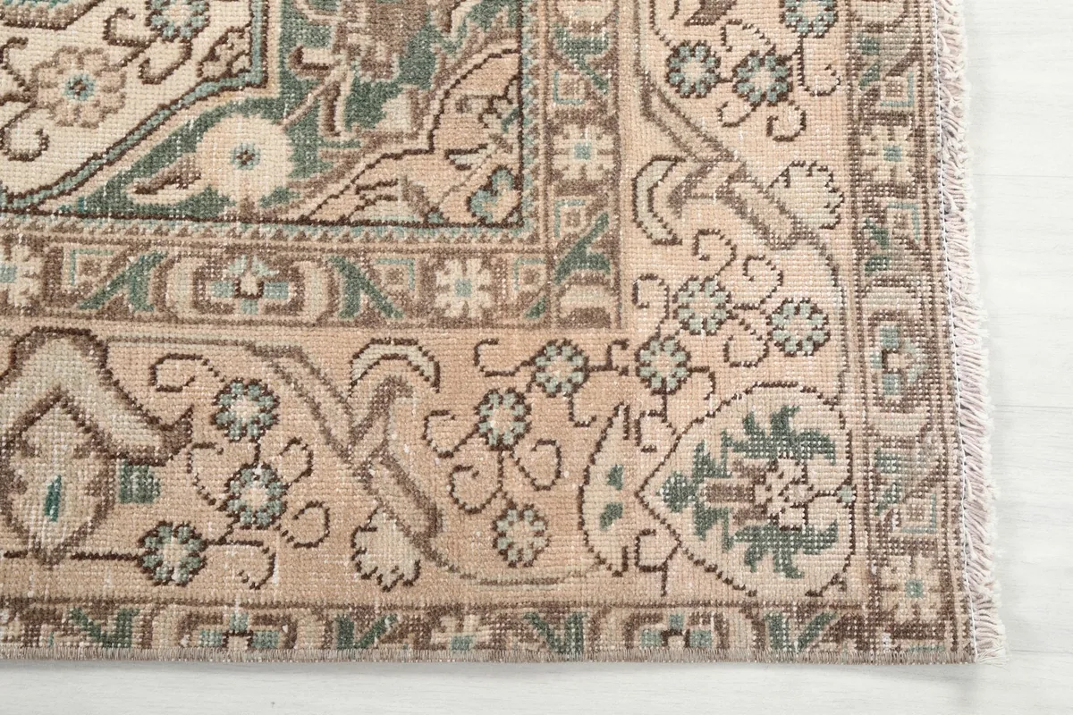 Detail of the corner border and field patterns in beige, blue, and brown