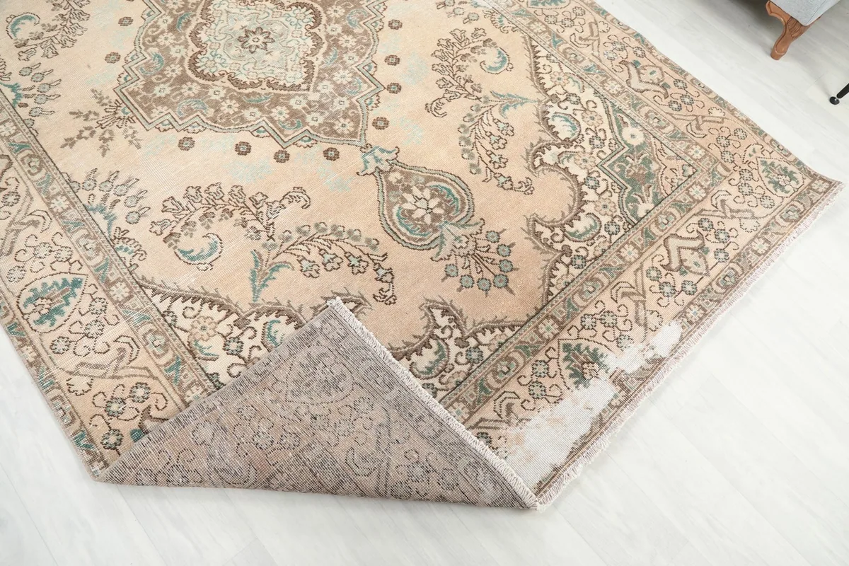 A corner of the hand-knotted rug folded back to show the cotton foundation