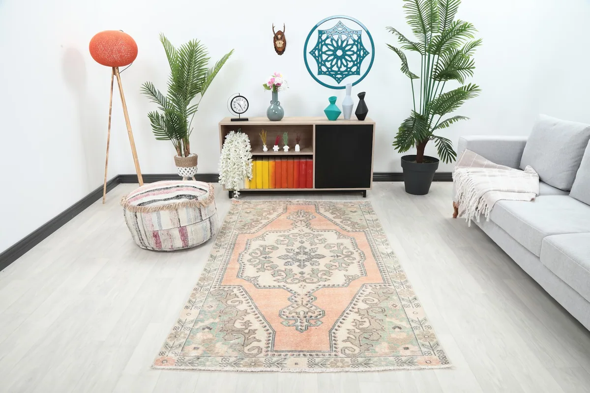 Vintage Anatolian rug displayed in a modern living room setting, showing its scale next to a sofa