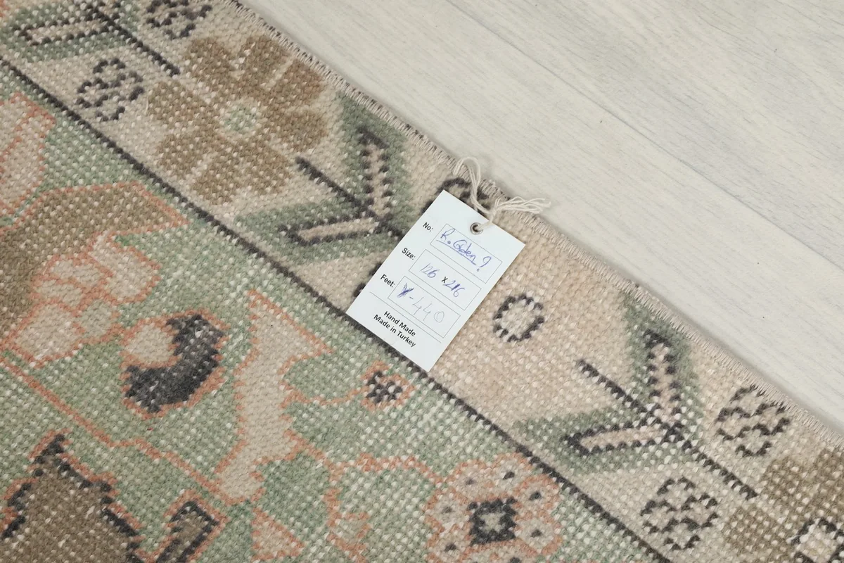 Rug tag displaying dimensions and material, with a partial view of the rug's border