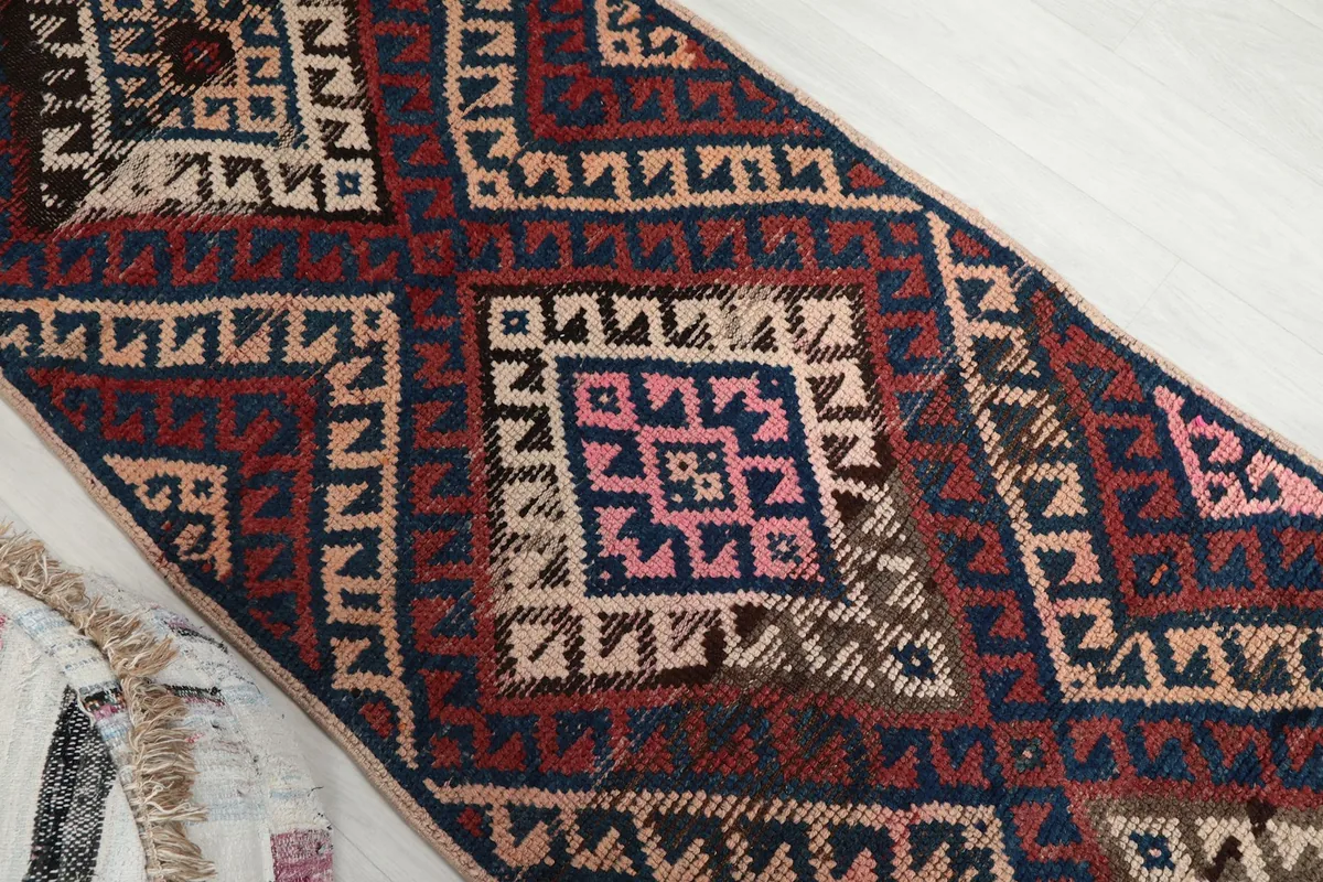 Overhead angle shot highlighting the intricate geometric motifs and color variations in the vintage runner.