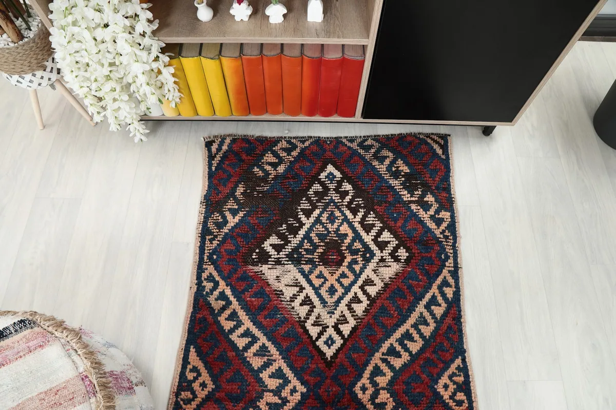 Overhead view of a section of the runner rug, focusing on the repeating geometric diamonds and varied color tones.