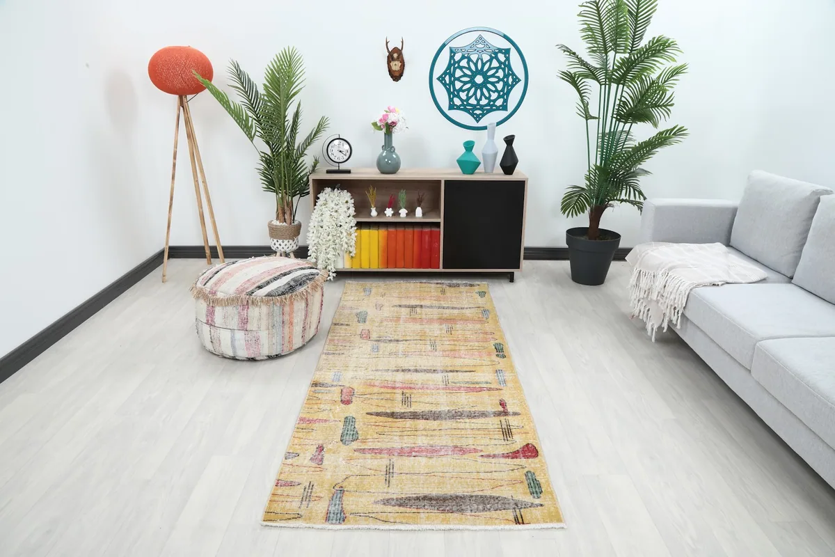 Gold abstract runner placed in a modern living room setting with a gray sofa and plants