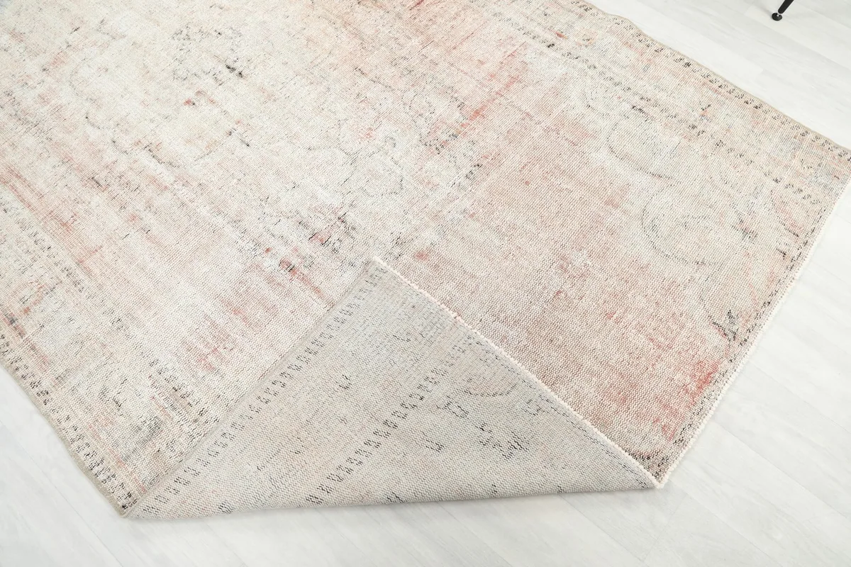 Folded corner of the rug, revealing the thickness of the wool pile and cotton foundation.