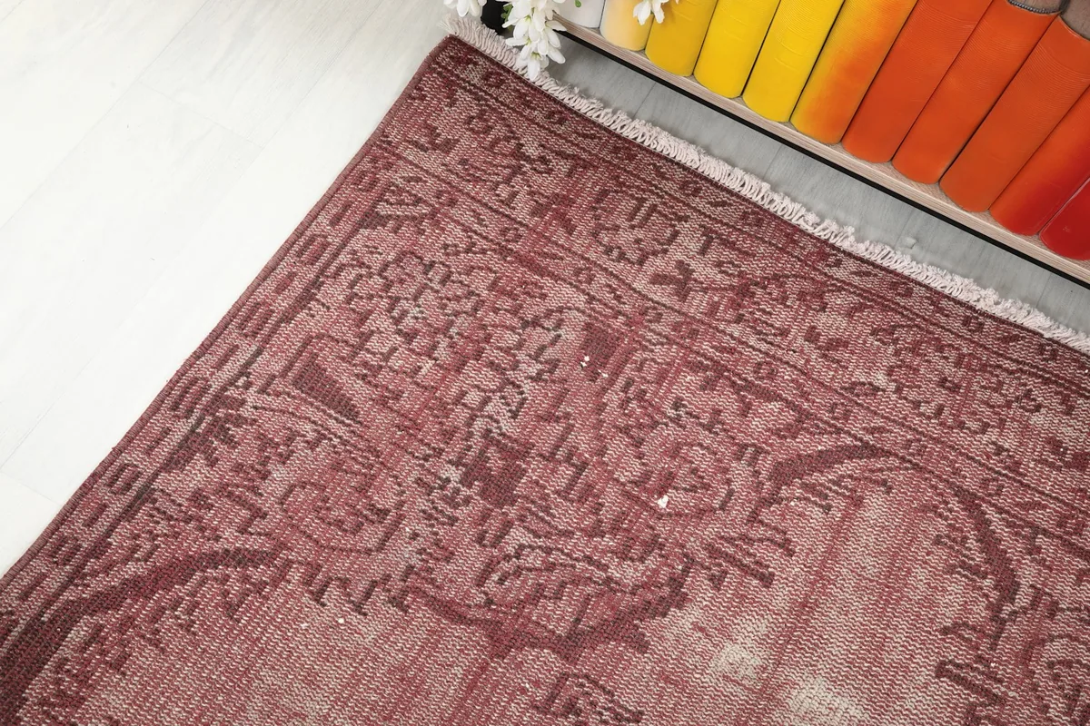 Corner view of the rug showing the faded rose field and intricate border design