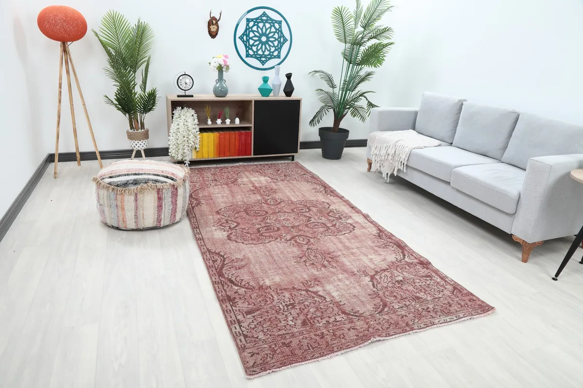 Overhead angle of the rose vintage rug in a living room, showing its full length