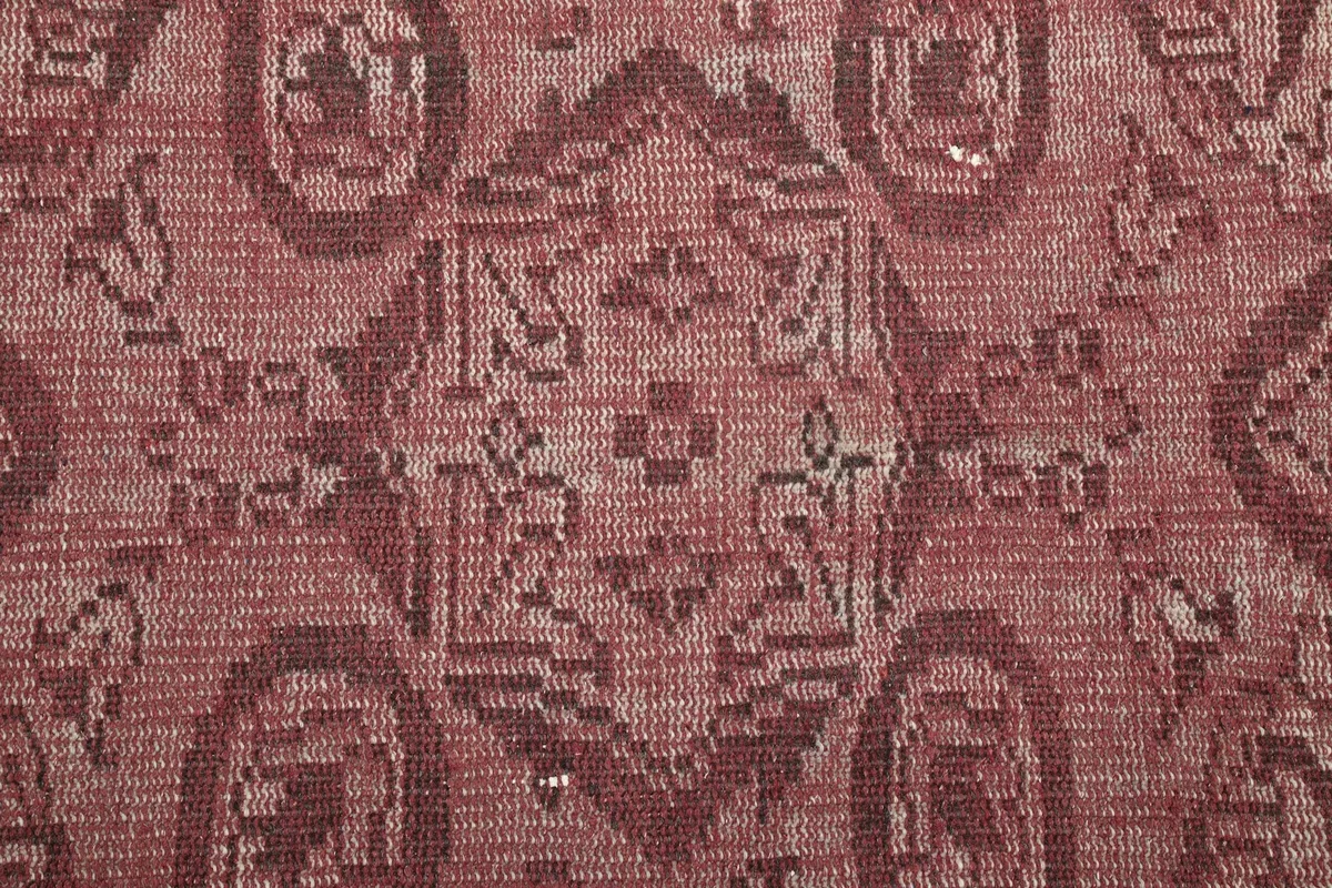 Tight detail of the hand-knotted texture and geometric elements within the medallion