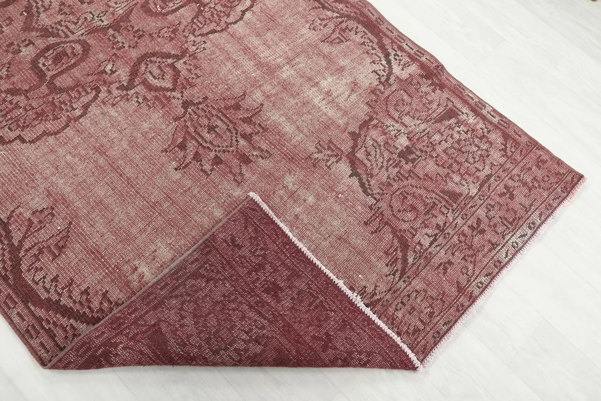 Folded corner of the rug revealing the wool pile and cotton foundation