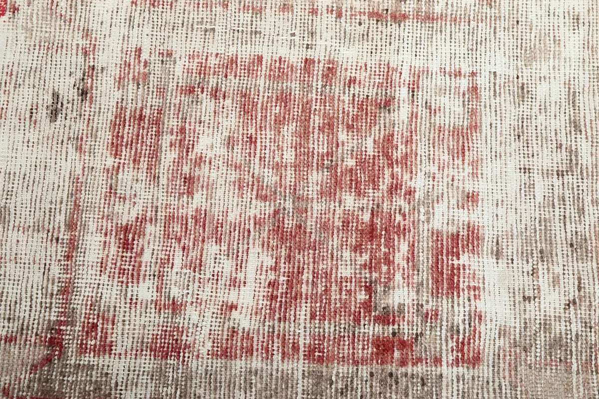 Detailed view of the distressed rose color and intricate geometric design on the rug