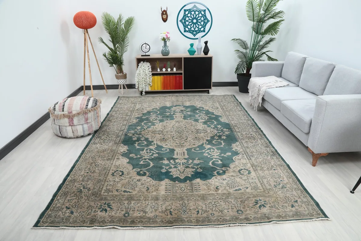 Vintage Anatolian rug displayed in a living room setting with a gray sofa and plants