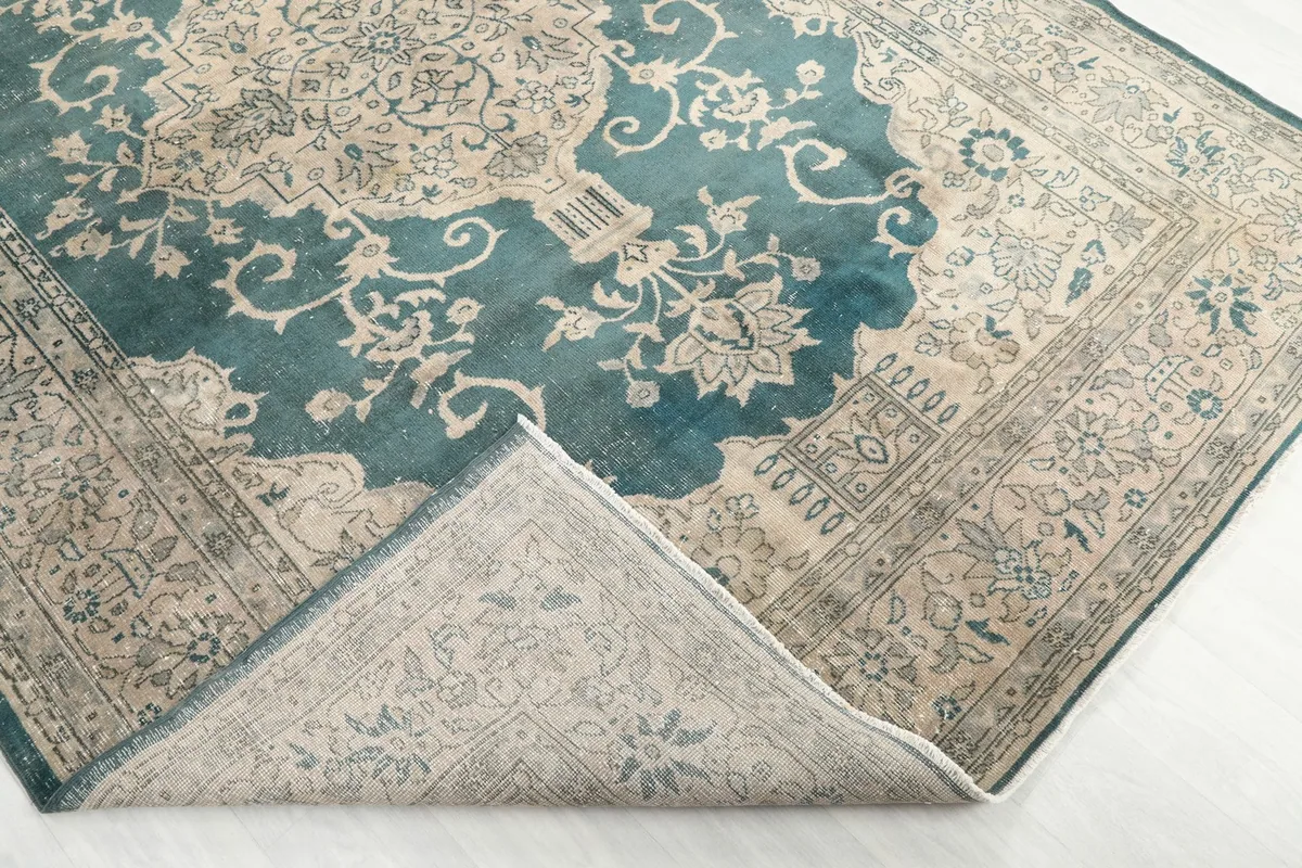 Corner of the rug folded back to reveal the cotton foundation and hand-knotted construction