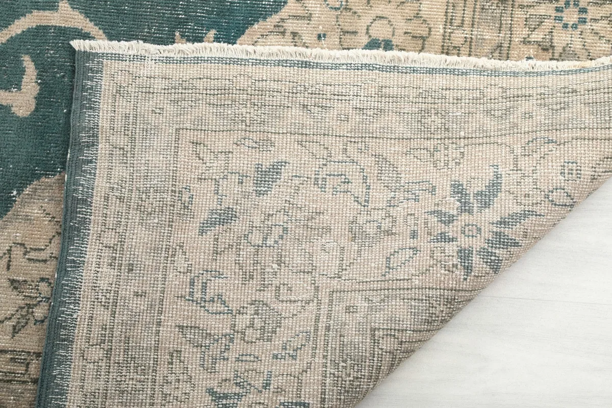 Close-up of the rug's edge and fringe, showing the texture and weave of the back