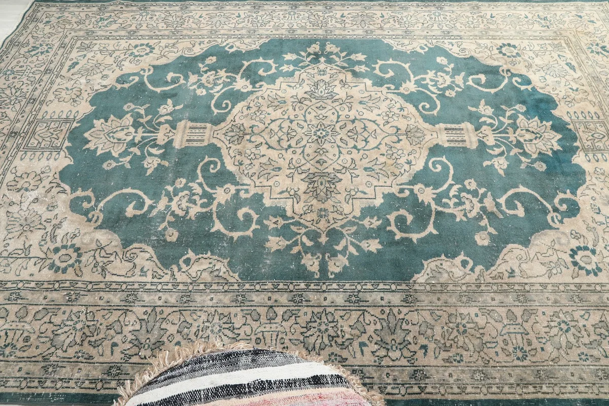 Overhead view of the rug's center, emphasizing the blue medallion and surrounding beige field