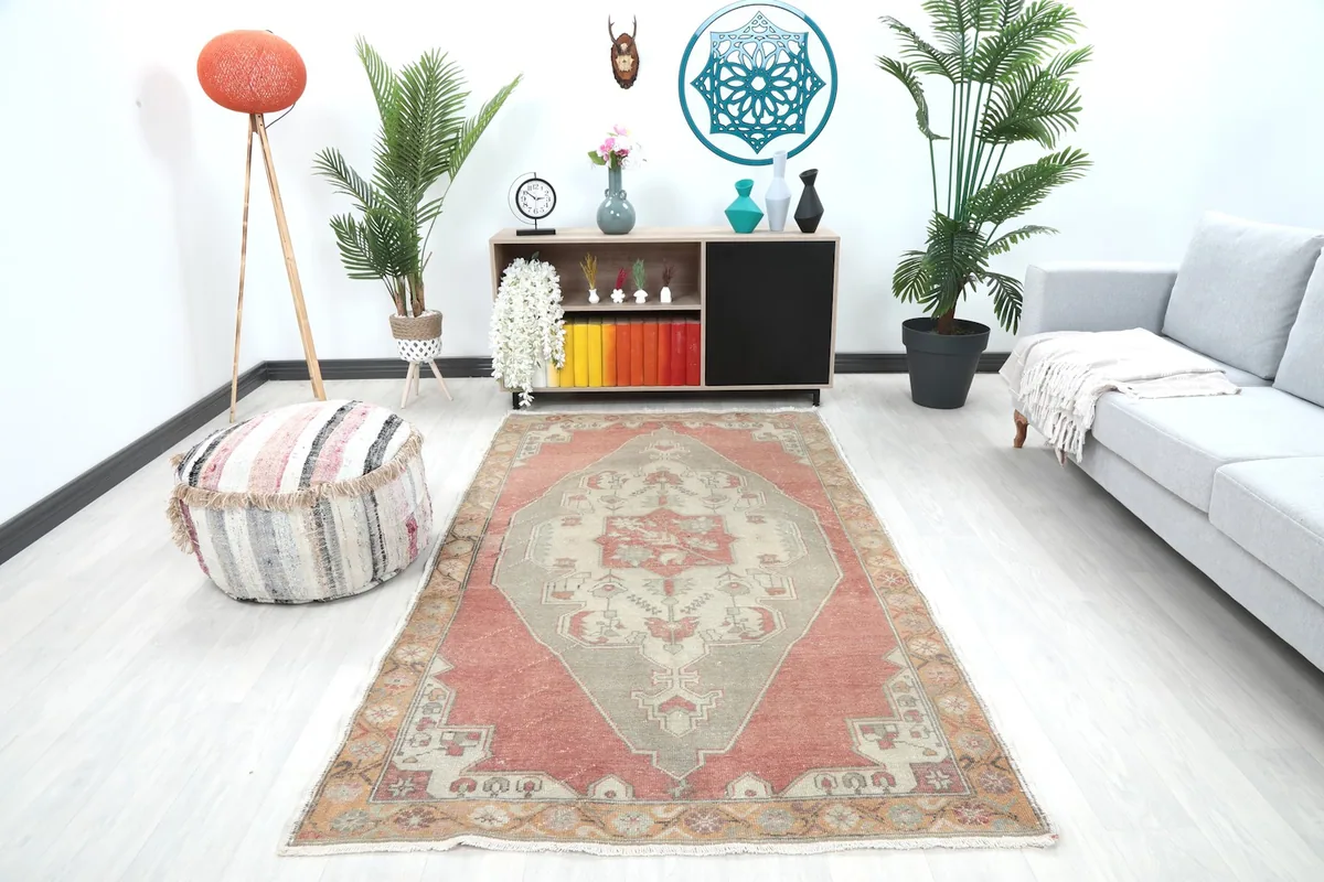Vintage Anatolian rug displayed in a living room setting with a sofa and pouf