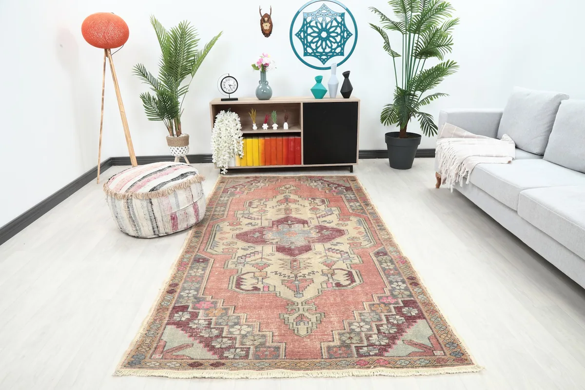 Vintage Anatolian rug displayed in a bright living room setting with a couch and ottoman