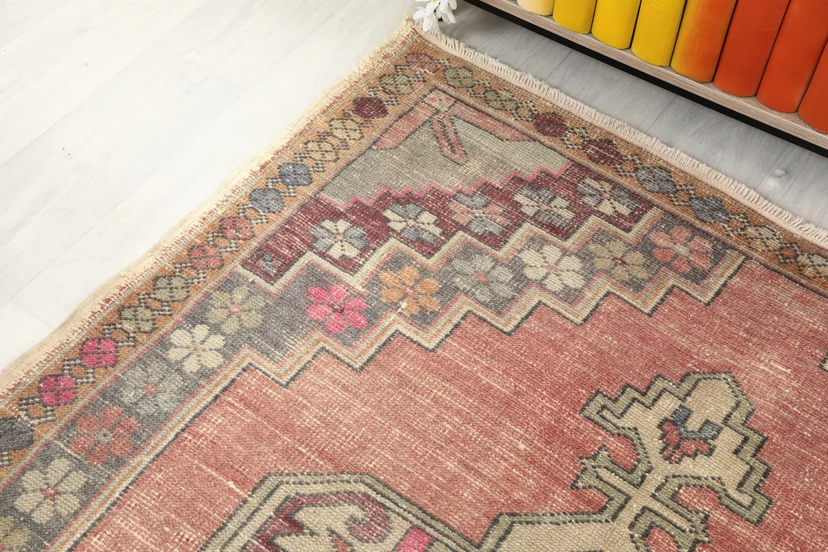 Detail of the rug's border with floral and geometric patterns in various colors