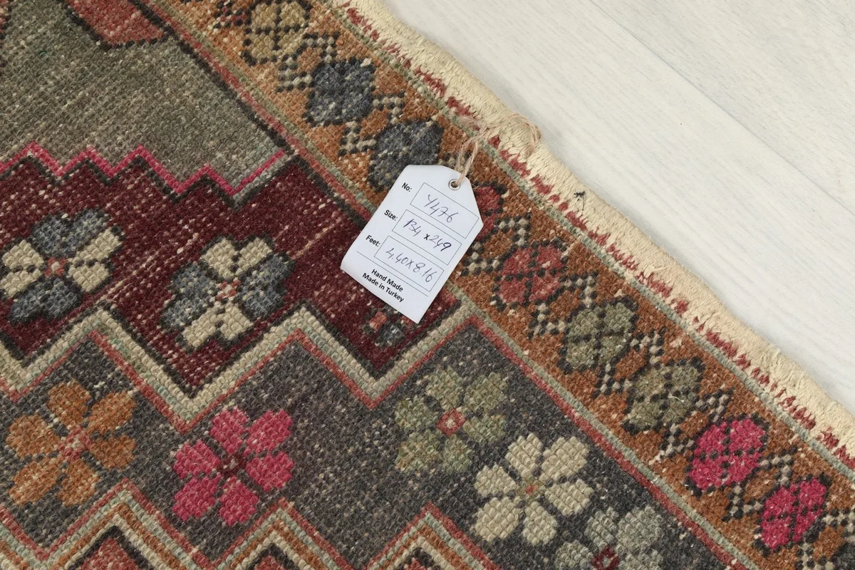 Corner of the rug with an identification tag, showing the intricate border weaving